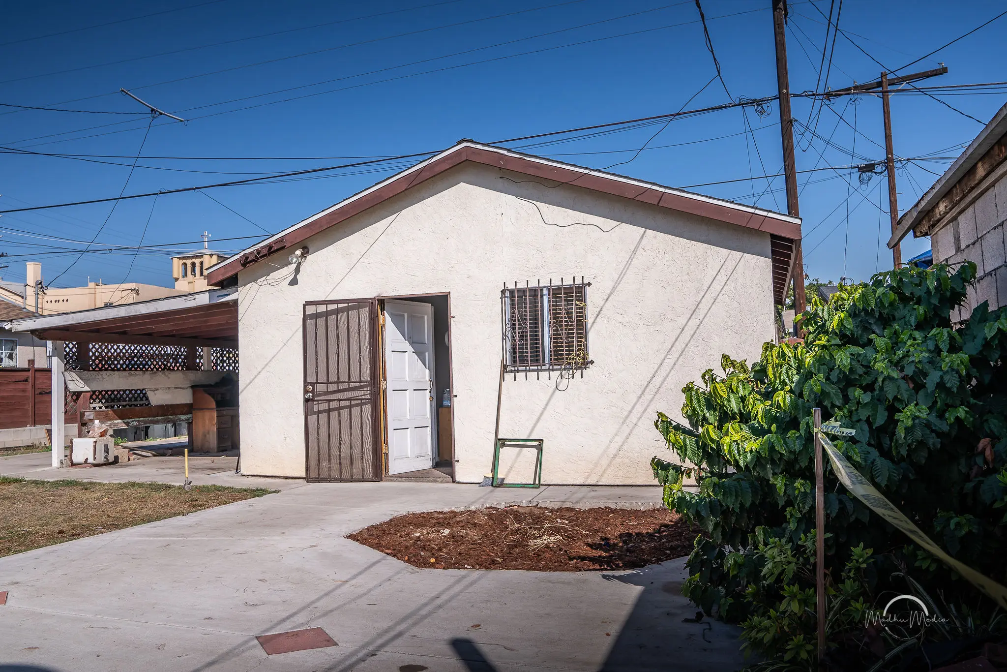 Small house with garden and wires overhead.