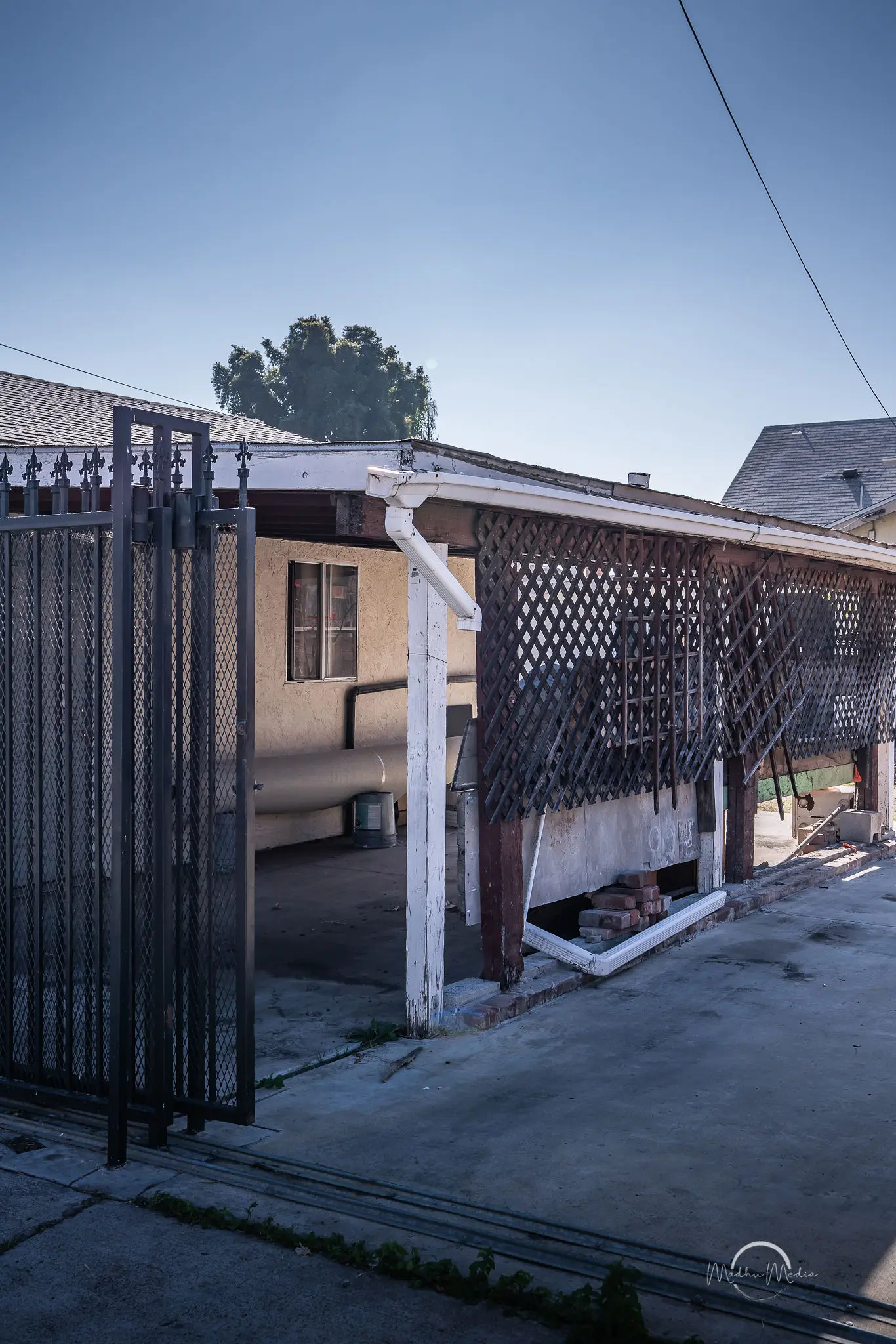 House with a carport and metal gate.