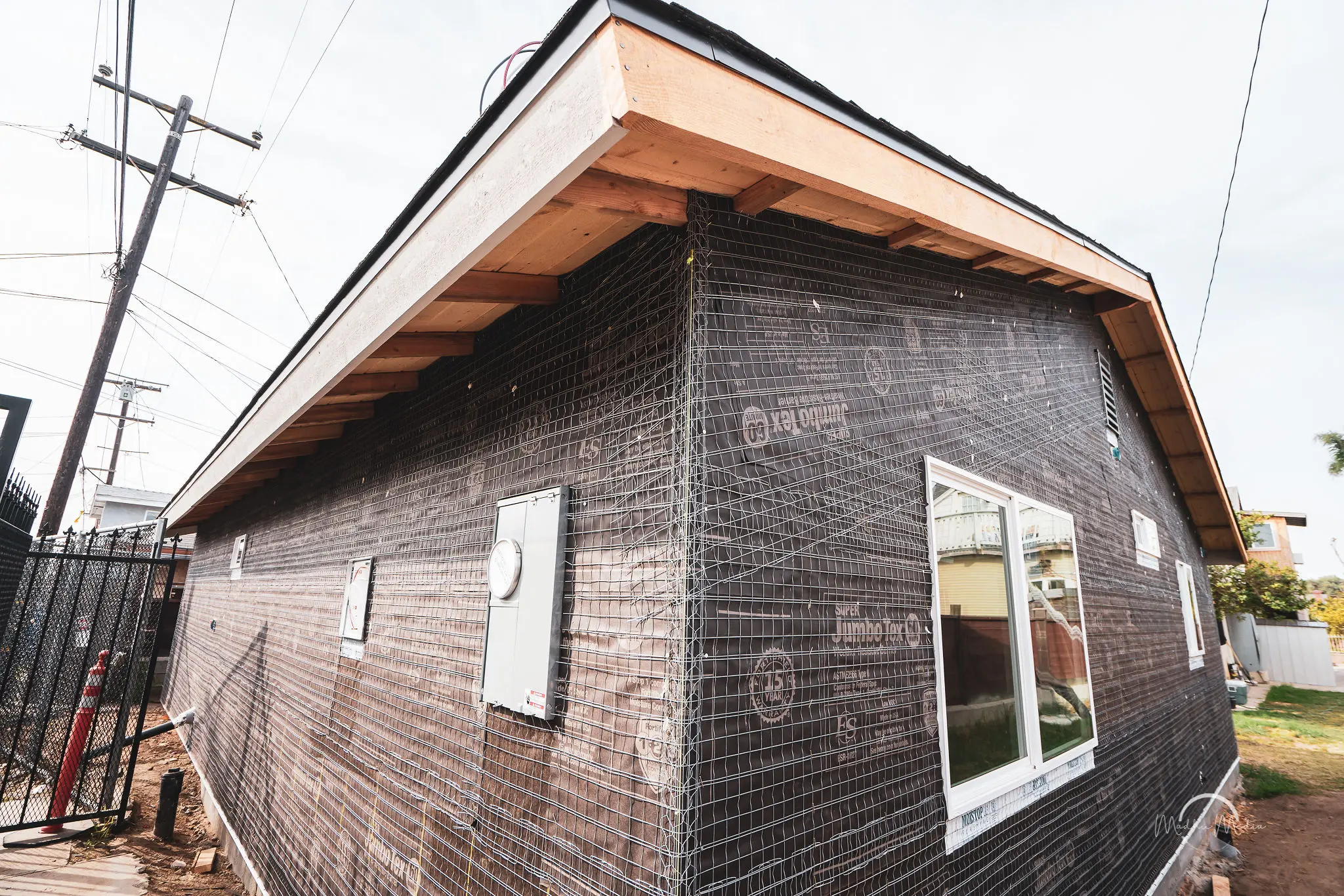 House under construction with black mesh wrapping.